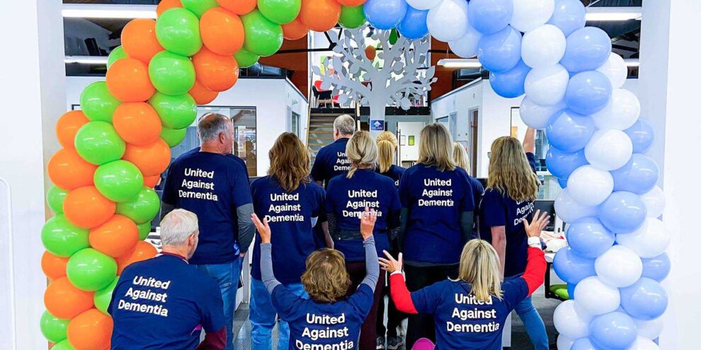 People wearing Alzheimer's t-shirts before the annual Prime Appointments Memory walk with corporate balloons
